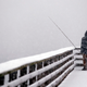 A person looks out toward the cityscape lost in a whiteout as he fishes from a pier during a snowstorm Friday, Feb. 8, 2019, in Seattle.